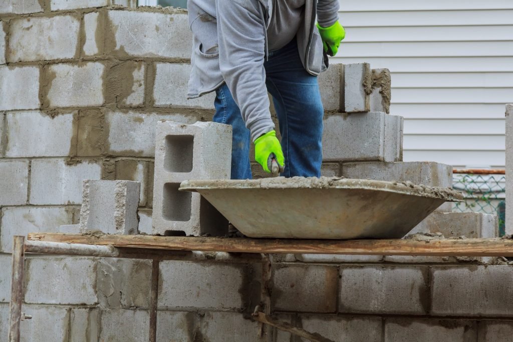 Bricklayers new house wall on foundation hands with in masonry bricklaying