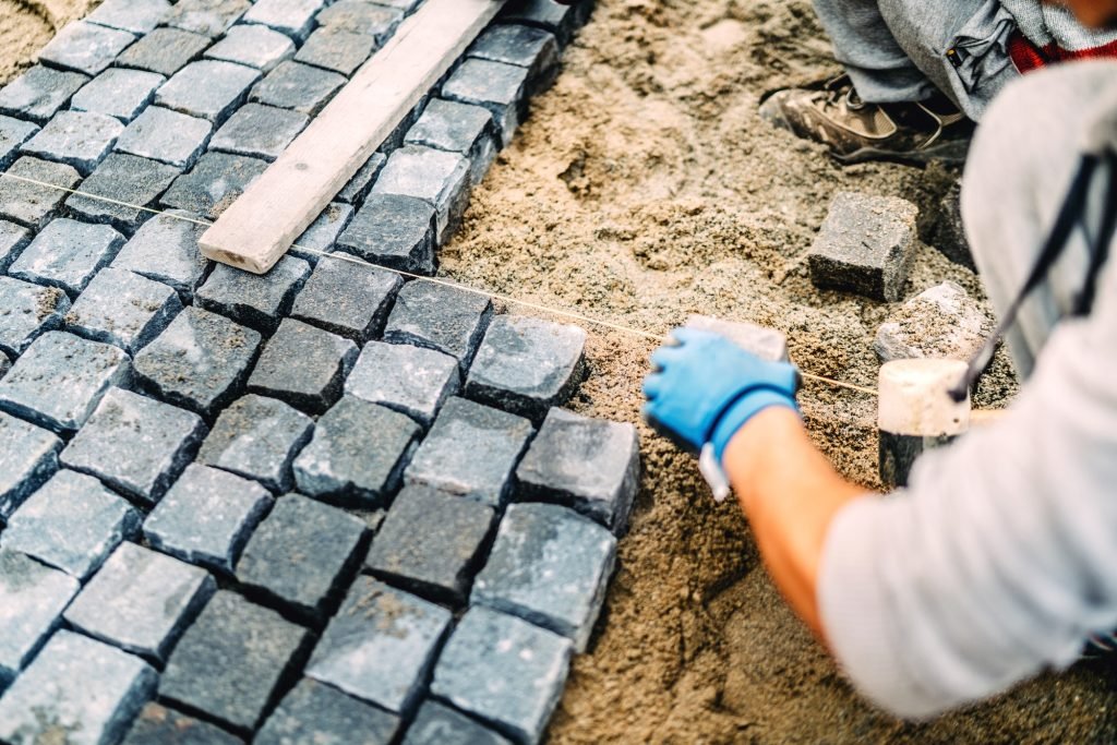 Construction worker details.Building of road or sidewalk with granite stone as pavement