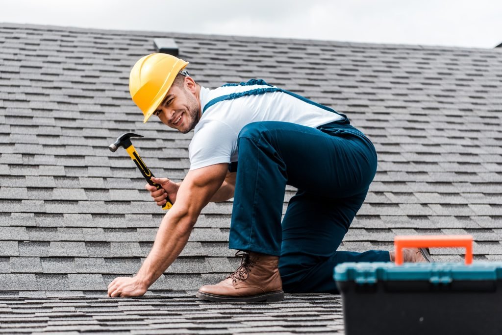 selective focus of handsome handyman repairing roof